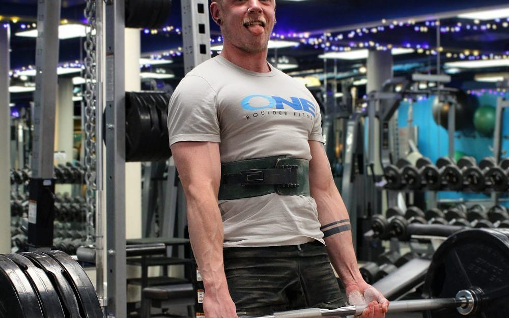 A ONE Boulder Fitness trainer setting up for a deadlift