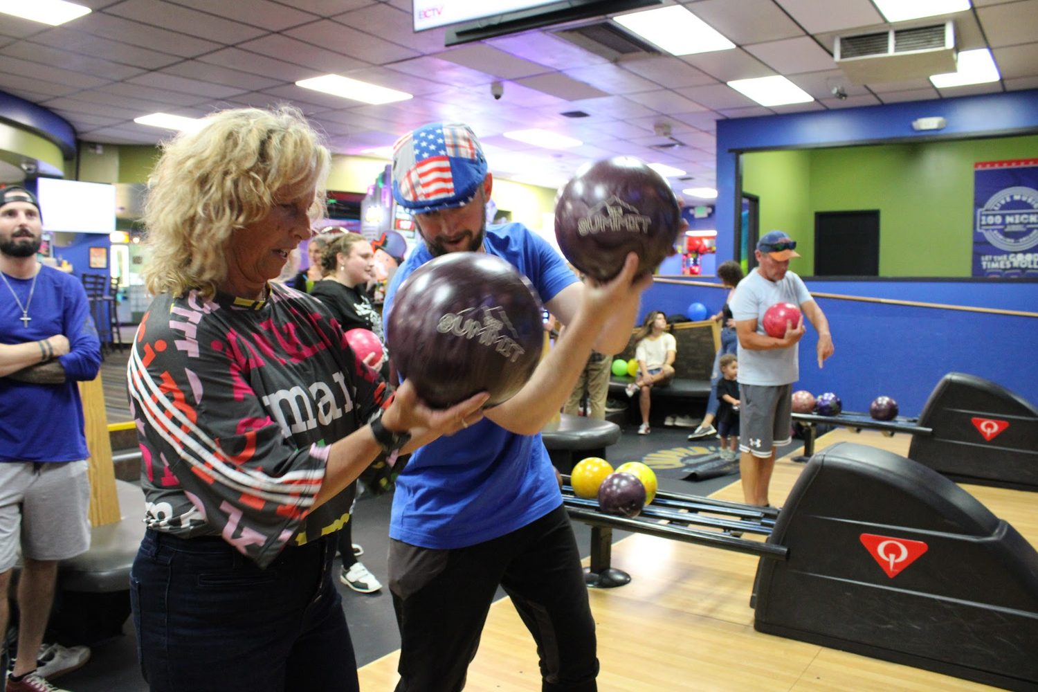 Karie Kerner handing a member a ball on the club's bowling night
