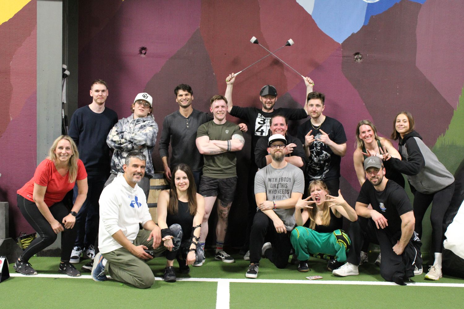 Members and trainers packed together on the turf under the Flatirons mural