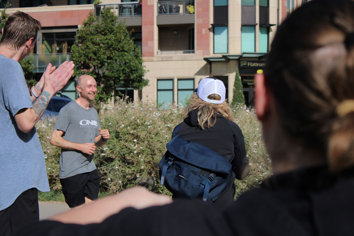 Members cheering a runner through on a downtown Boulder path
