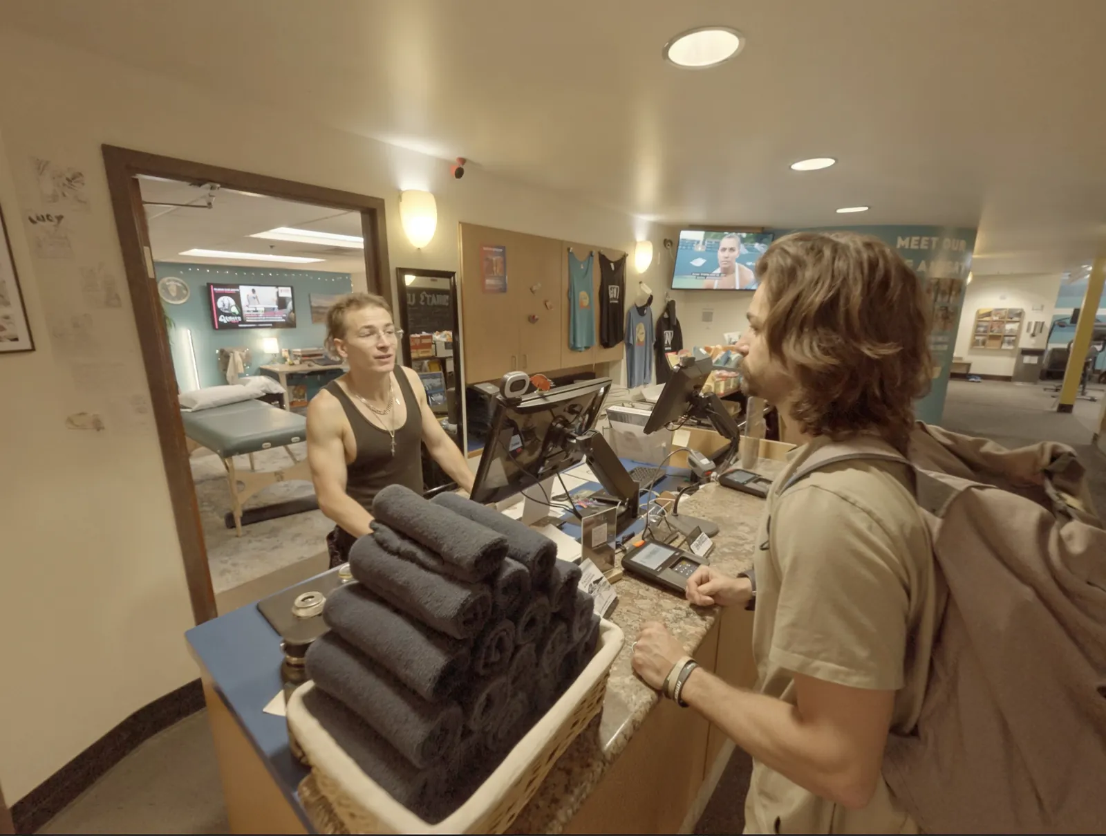 A member checking in with towels at the ONE Boulder Fitness front desk
