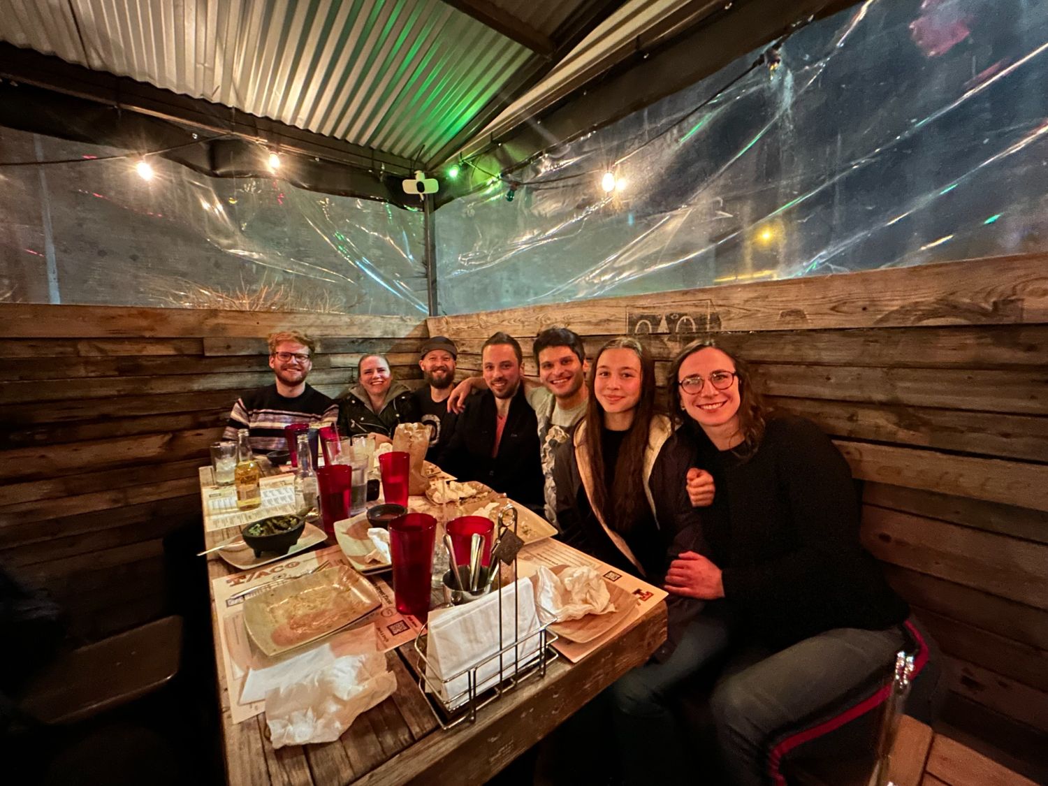 Members crowded into a booth at dinner together around the corner from the club
